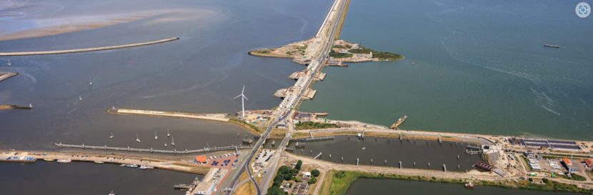 Dronebeeld van de Afsluitdijk. Open water met een gebouwde dijk